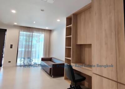 Modern living room with built-in wooden shelves and workspace