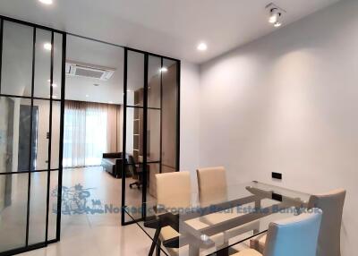 Modern dining area with glass table and beige chairs