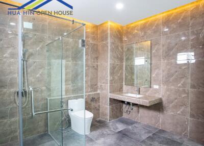 Modern and spacious bathroom with glass shower enclosure and ambient lighting