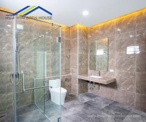 Modern and spacious bathroom with glass shower enclosure and ambient lighting