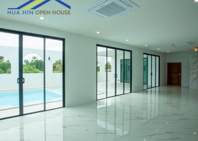 Open living space with glass doors and view of the pool