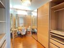 Spacious walk-in closet with wooden flooring and seating area