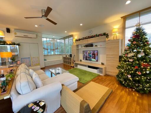 Spacious living room with Christmas decorations, a large sofa, and a TV unit