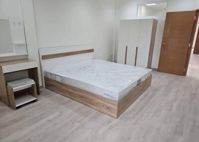 Modern bedroom with wooden furniture and laminate flooring