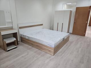 Modern bedroom with wooden furniture and laminate flooring