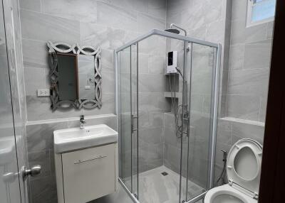 Modern bathroom with shower, vanity, and toilet