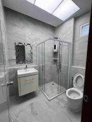 Modern bathroom with shower, vanity, and toilet