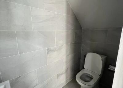 Modern bathroom with tiled walls and a toilet