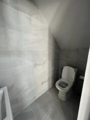 Modern bathroom with tiled walls and a toilet