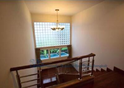 Staircase with large glass window and chandelier