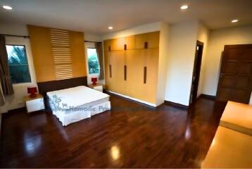 Spacious modern bedroom with wooden floor and built-in wardrobe