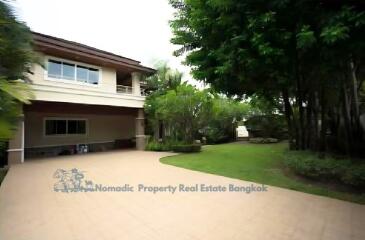 Exterior view of a house with a spacious driveway and green lawn