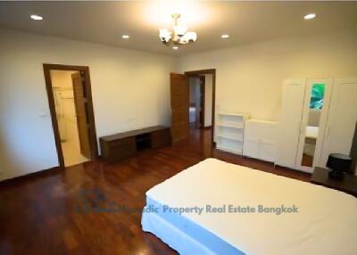 Spacious bedroom with hardwood floors and ample storage