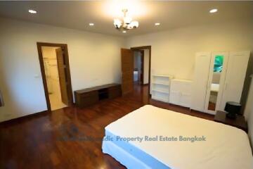 Spacious bedroom with hardwood floors and ample storage