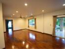 Spacious living room with wooden floors and large windows