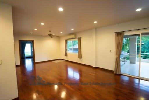 Spacious living room with wooden floors and large windows