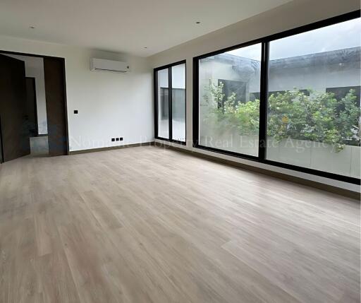 Spacious living room with large windows and wood flooring