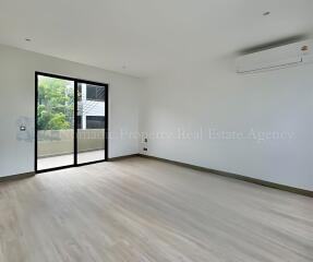 Spacious empty living room with large sliding glass door and balcony view