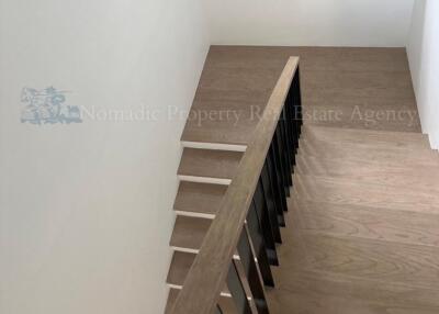 Modern wooden staircase with dark railings