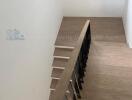 Modern wooden staircase with dark railings