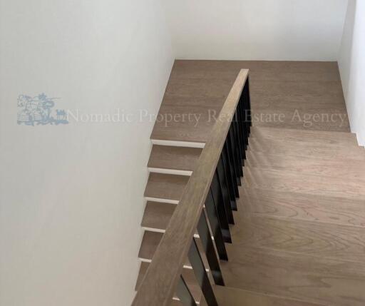 Modern wooden staircase with dark railings