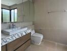 Modern bathroom interior with a large mirror, vanity with marble countertop, and a toilet.