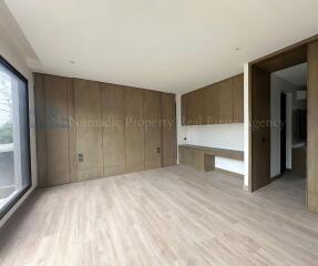 Spacious bedroom with wooden flooring and built-in closets