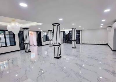 Spacious main living area with tiled flooring and decorative columns