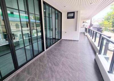 Spacious balcony with large glass doors and a mounted television