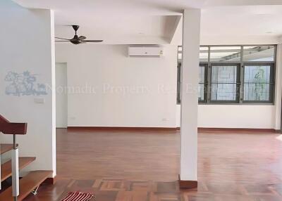 Spacious living room with wooden flooring and large windows