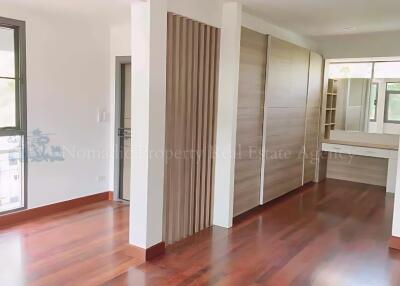 Spacious bedroom with wooden floors and closet