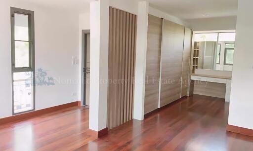 Spacious bedroom with wooden floors and closet