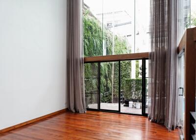 Spacious living room with large floor-to-ceiling windows and wooden flooring