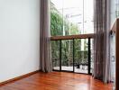 Spacious living room with large floor-to-ceiling windows and wooden flooring