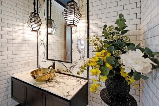 Stylish modern bathroom with marble countertop and floral arrangement