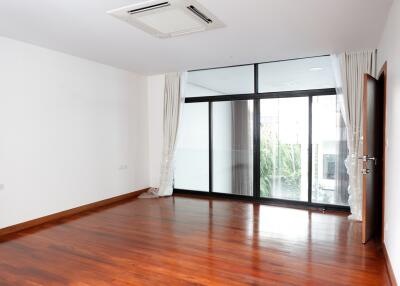 Spacious living room with large windows and wooden flooring