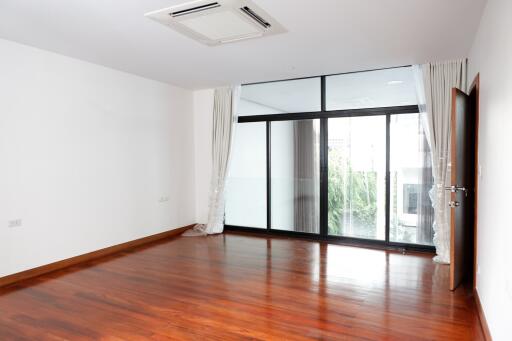 Spacious living room with large windows and wooden flooring