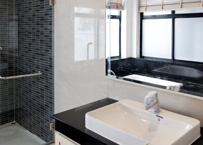 A modern bathroom with a glass shower and a large mirror