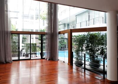 Spacious room with large windows and pool view in modern building