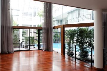 Spacious room with large windows and pool view in modern building