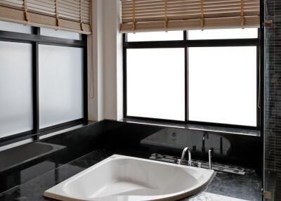 Modern bathroom with large windows and a built-in bathtub