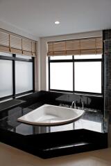 Modern bathroom with large windows and a built-in bathtub