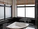 Modern bathroom with large windows and a built-in bathtub