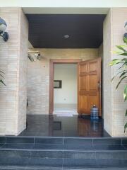 Main entrance with wooden door and dark tiled steps