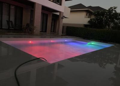 Outdoor pool area with colorful pool lights at dusk