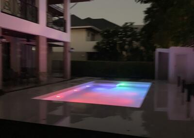 Outdoor area with illuminated swimming pool at dusk