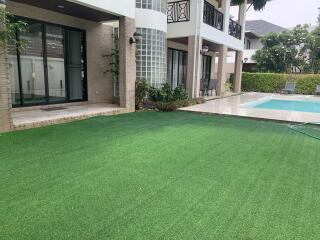 Outdoor area with artificial lawn and pool