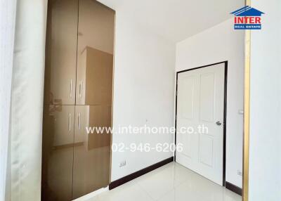 Bedroom with a white door, built-in wardrobe, and bright lighting