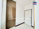 Bedroom with a white door, built-in wardrobe, and bright lighting