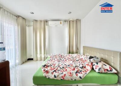 Bright bedroom with double bed and curtains